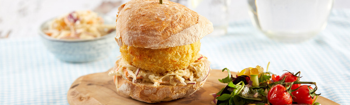 Salmon burger coated in air bag farina with a crusty bun, crab coleslaw and a confit lemon salad
