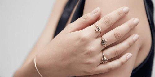 what is a signet ring? a woman wearing 3 gold signet rings on her right hand.