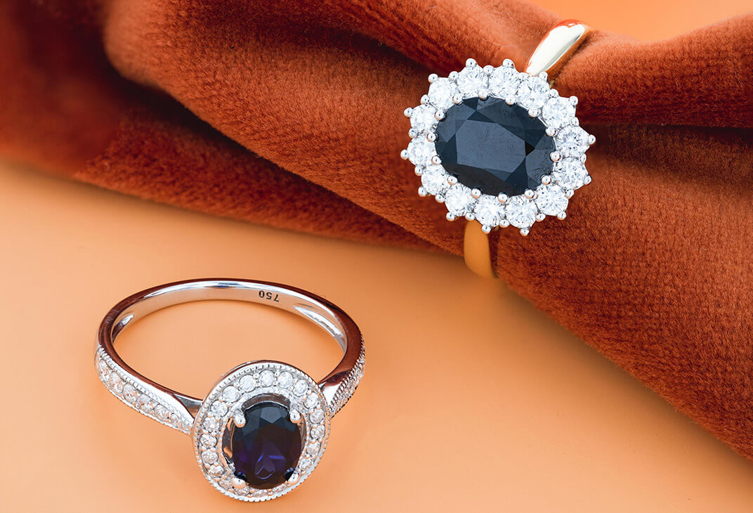 Do Men Wear Promise Rings? Two black sapphire rings laid flat over orange material.