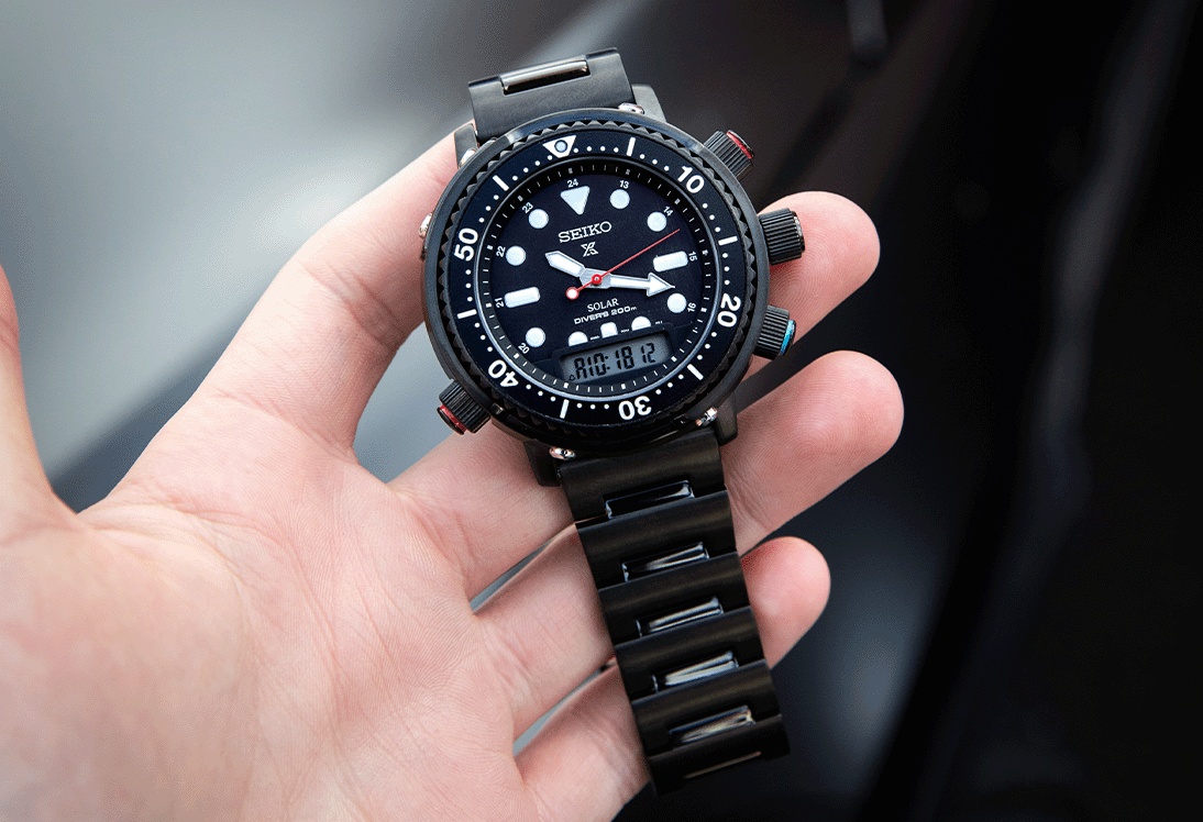 Seiko Hybrid Diver. Prospex SNJ037P with black case and bracelet held in hand 