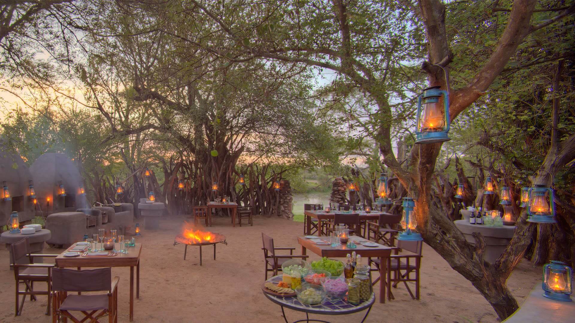 Bush sundowner with lantersn and tables and a firepit